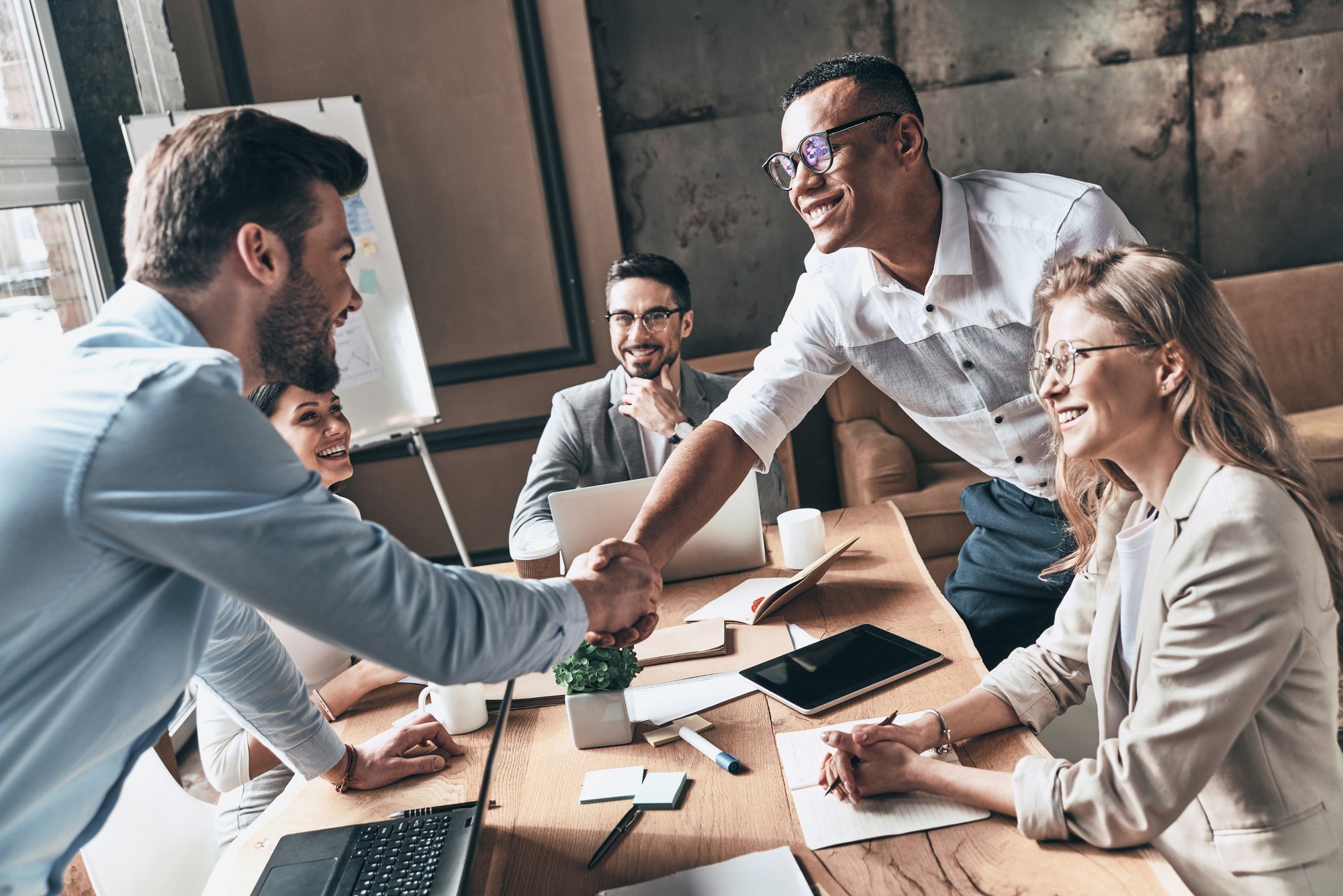 People in a meeting and shaking hands during a meeting.