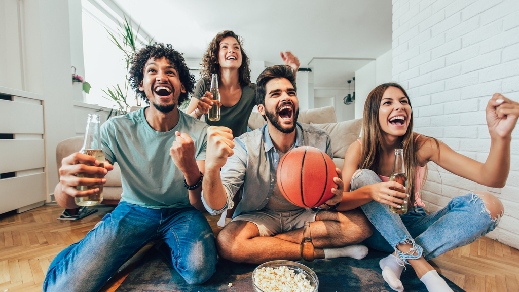 Group of friends watching a basketball game on television.