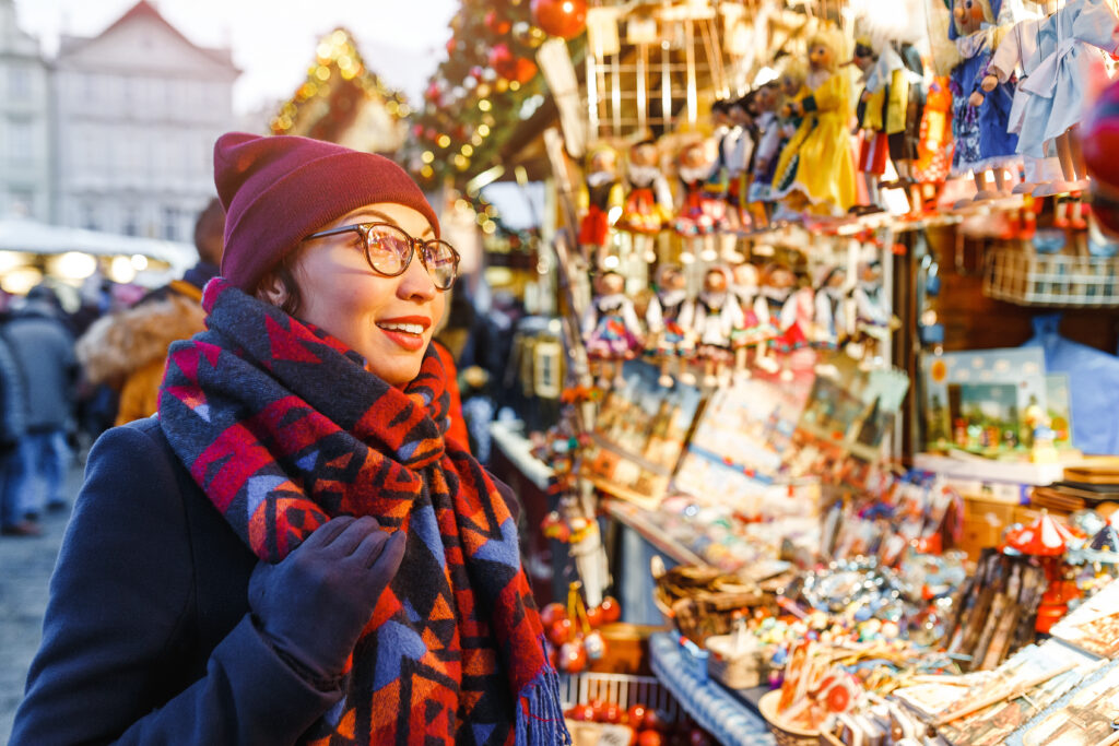 A holiday shopper visits a gift stand at a Christmas market.