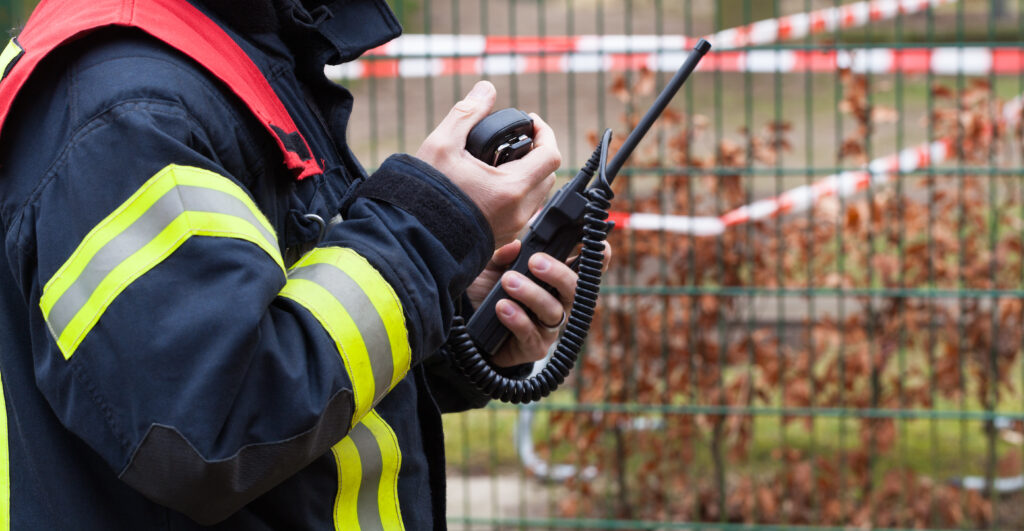 A firefighter responds to a call over their radio.