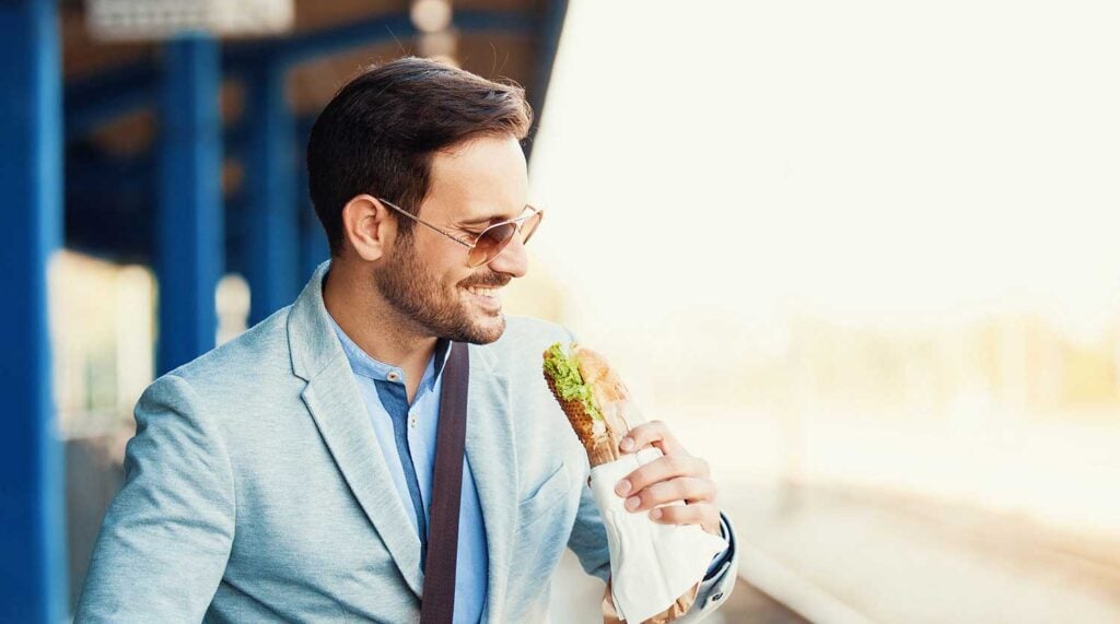 Business man enjoys a submarine sandwich