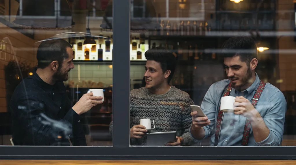 Three friends enjoy coffee together in a local coffee shop
