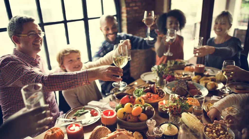 A multicultural family raises a toast over a colorful Thanksgiving holiday meal
